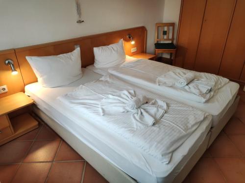 a large bed with white sheets and towels on it at Apartment Biber in Dewichow