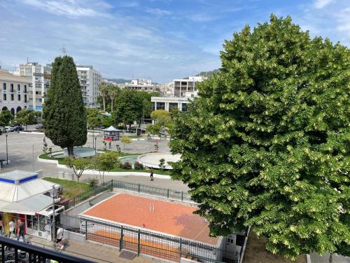 a large tree next to a tennis court at Kavala Central Square View in Kavala