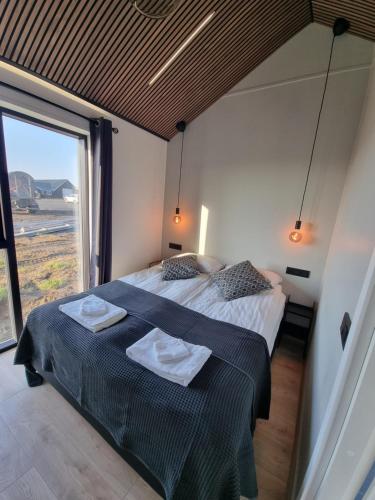 1 dormitorio con 1 cama con 2 toallas en Arctic Exclusive Ranch, en Kirkjubæjarklaustur