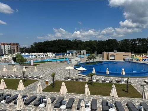 a swimming pool with umbrellas and chairs and a resort at NOVAK apartman in Vrnjačka Banja