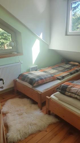 two beds in a room with a white rug at Całoroczny duży dom na Mazurach n.Jeziorem Omulew. in Jabłonka