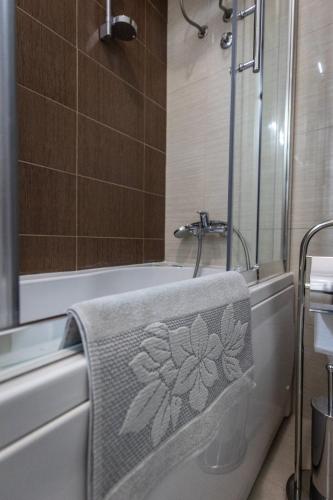 a bathroom with a towel on the side of a bath tub at Vila Palić Soba 1 lux in Palić
