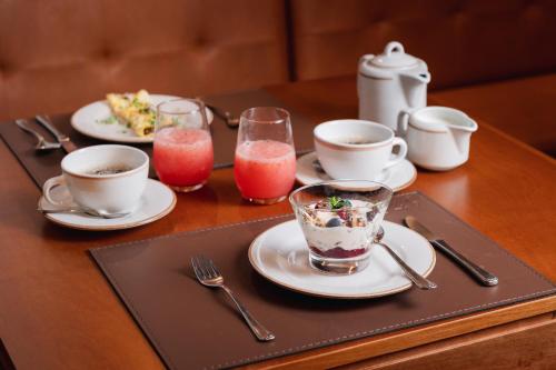 una mesa con platos de comida, tazas y utensilios en 249 DESIGN HOTEL, en Gramado