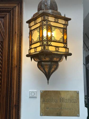a chandelier hanging on a wall next to a sign at Kasba blanca in Tangier