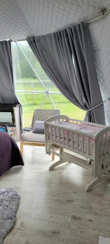 ein Schlafzimmer mit einem Bett und einem Sofa in einem Zelt in der Unterkunft Glempings Anemones in Plieņciems