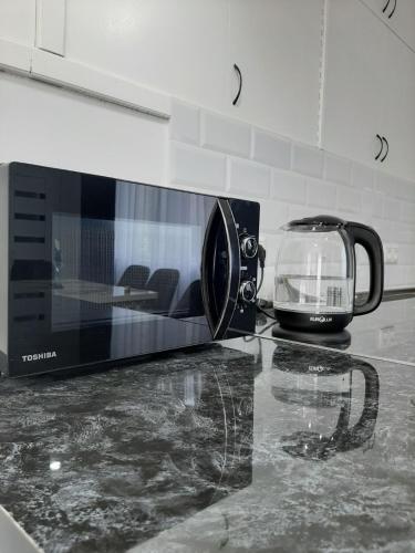 a kitchen counter with a microwave and a toaster at Vernatun guest house in Gyumri