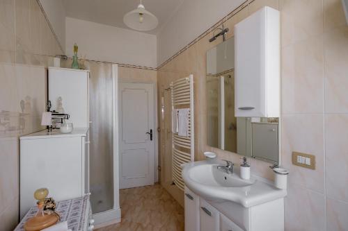 a white bathroom with a sink and a mirror at Lignanello Country House in Pienza