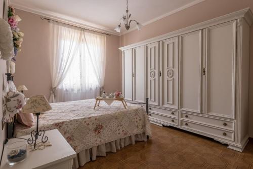 1 dormitorio con 1 cama, vestidor y ventana en Lignanello Country House, en Pienza
