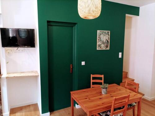 Habitación verde con mesa de madera y puerta verde. en Maison de ville entière proche centre, en Amiens