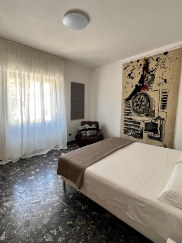 una camera con un grande letto e una sedia di Appartamento Funtanedda - Affitti Brevi Italia a Triei