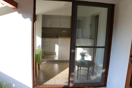 Habitación con una puerta de cristal que da a una cocina. en Apartments Leo Katić en Lastovo