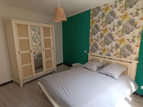 - une chambre avec un lit blanc et un mur fleuri dans l'établissement Maison au cœur d'un petit village provençal proche Vaison la Romaine, à Saint-Romain-en-Viennois