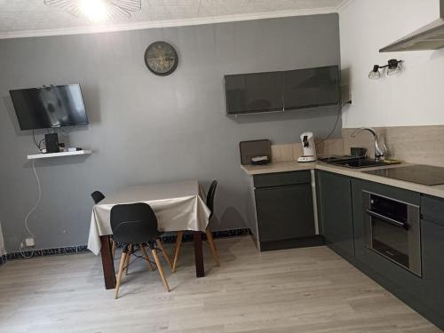 - une cuisine avec une table, une petite table et des chaises dans l'établissement Maison au cœur d'un petit village provençal proche Vaison la Romaine, à Saint-Romain-en-Viennois