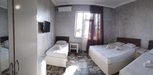 a room with two beds and a window at MIDIA Guest House in K'obulet'i
