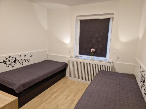 a small room with two beds and a window at Guest House Rens in Bylderup-Bov