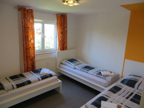 - une chambre avec 2 lits et une fenêtre dans l'établissement Ferienwohnung BELVEDERE Orange, à Rust