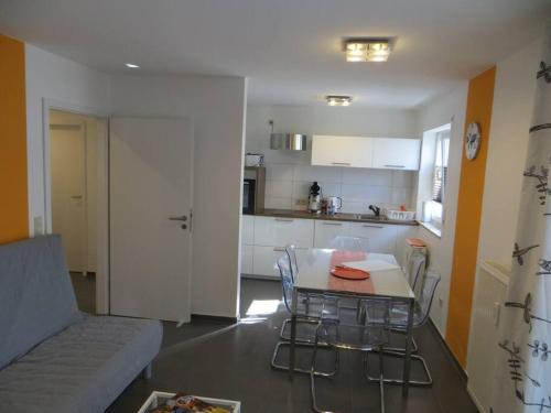 eine Küche und ein Wohnzimmer mit einem Tisch und Stühlen in der Unterkunft Ferienwohnung BELVEDERE Orange in Rust