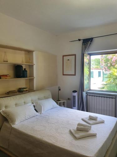 a bedroom with a large bed with towels on it at Andrea's House in Fiumicino