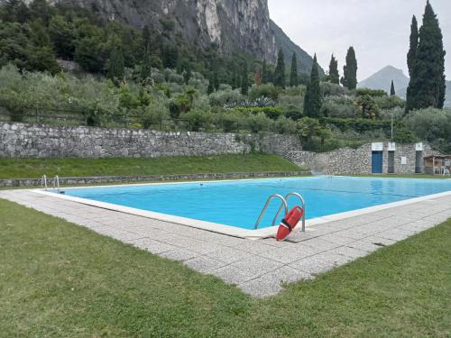 una piscina con un paio di scarpe rosse accanto di L'angolo di pace e relax del lago di Garda a Riva del Garda