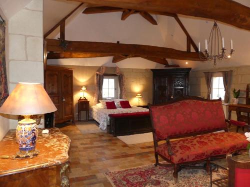 a bedroom with a bed and a couch and a table at Demeure de Maugé in Saint-Léger-de-Montbrillais