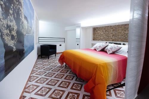 a bedroom with a bed with a colorful blanket at Mori Carretti Tamburelli in Ispica