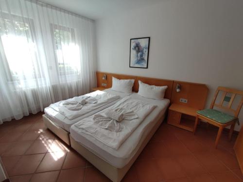 a bedroom with a bed with white sheets and a chair at Ferienwohnung Achterwasser in Dewichow