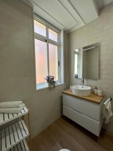 baño con lavabo, espejo y ventana en Cedemar 2, en Cedeira