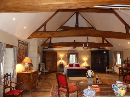 a large living room with a bed and a table at Demeure de Maugé in Saint-Léger-de-Montbrillais