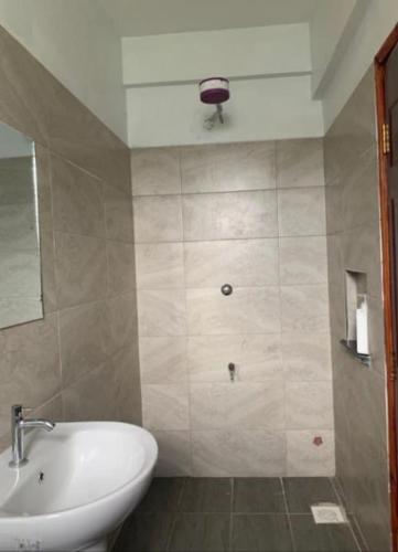 a bathroom with a sink and a toilet and a mirror at Grey Nest Grey point 303 in Kericho