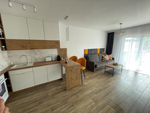 a kitchen and a living room with a couch at Apartament Dziwnów in Dziwnów