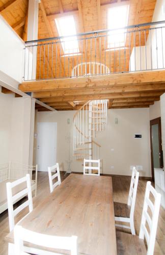 a large room with white chairs and a spiral staircase at Agriturismo Cascina della Fontana in Lodi