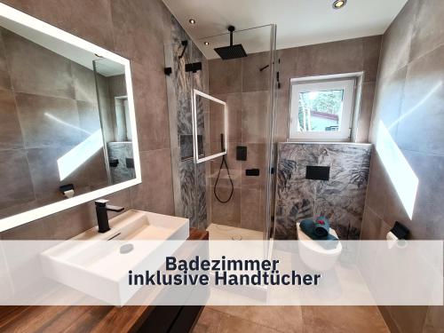 a bathroom with a sink and a shower and a mirror at Ferienhaus Rothsee-Oase ideale Ausgangslage mit tollem Ausblick, Sauna und privatem Garten in Roth