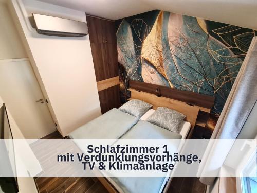 een kleine kamer met een bed en een schilderij aan de muur bij Ferienhaus Rothsee-Oase ideale Ausgangslage mit tollem Ausblick, Sauna und privatem Garten in Roth