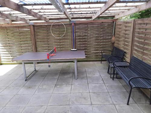 a ping pong table in a patio with two benches at Guest House Rens in Bylderup-Bov