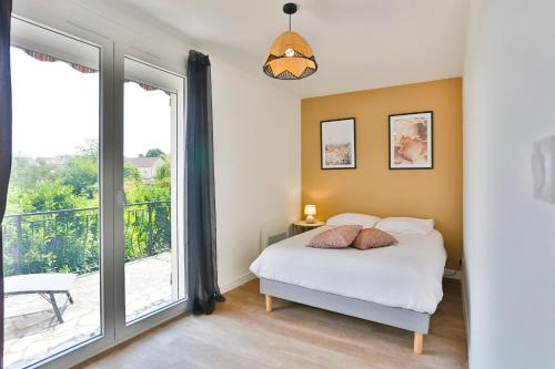 a bedroom with a bed and a balcony at Le chocolaté ~ Grand T2 gourmand in Vierzon