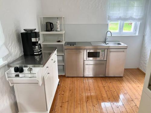 a kitchen with stainless steel appliances and a wooden floor at Mühlenhaus Herkenrath in Bergisch Gladbach