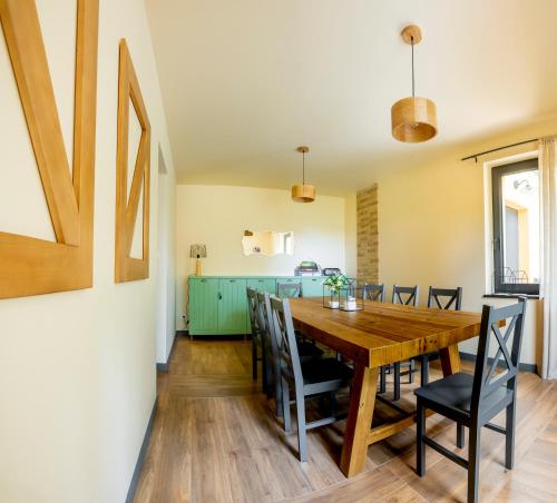 a dining room with a wooden table and chairs at WYWIAŁOWO in Olsztyn