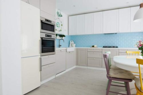 a kitchen with white cabinets and a table and chairs at Casa Good Vibes in Târgu-Mureş