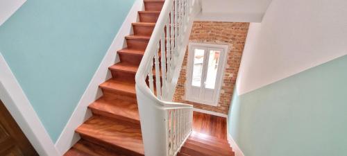 a staircase with white railings and wood floors at COSY Apartment AREETA STATION las Arenas Getxo in Getxo
