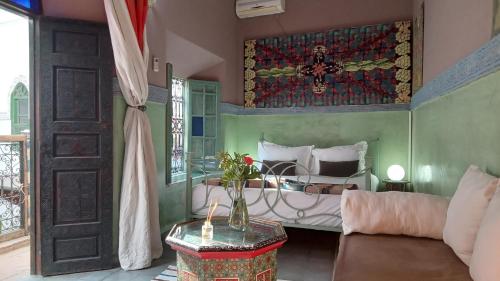1 dormitorio con 1 cama y 1 sofá en Riad Maizie, en Marrakech