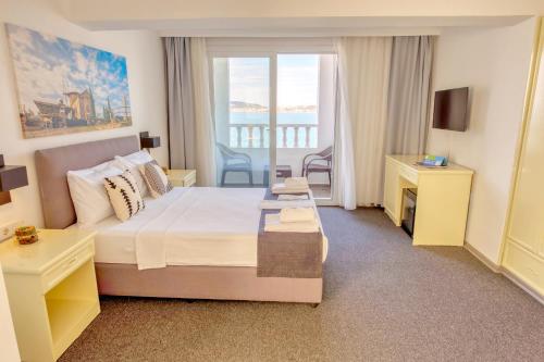 a hotel room with a bed and a balcony at Çamlık 87 Hotel Ayvalık in Ayvalık