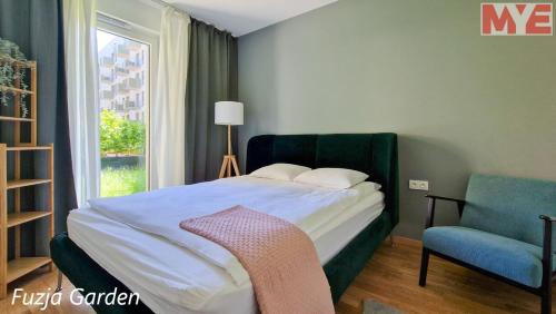 sypialnia z łóżkiem, krzesłem i oknem w obiekcie MYE_Fuzja w Łodzi