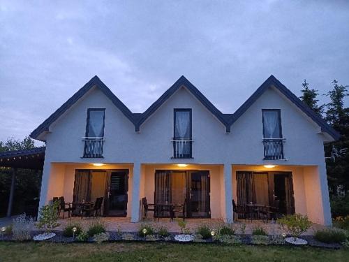 a white house with windows and chairs on it at Malaga in Gąski