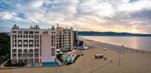 ein großes Gebäude am Strand neben dem Wasser in der Unterkunft Viand Hotel - Premium All Inclusive in Sonnenstrand