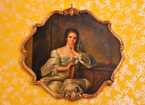 a painting of a woman sitting on a table at La Dolce Vita - Luxury House in Agrigento