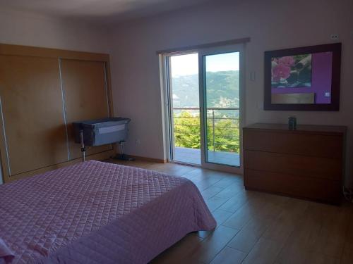 a bedroom with a bed and a sliding glass door at Casa da Bela Vista in Braga