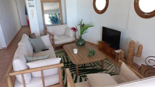 a living room with a white couch and a table at vue panoramique Marina in Le Marin