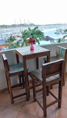 a table and chairs with a table and a view of a harbor at vue panoramique Marina in Le Marin