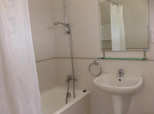 Un baño con lavabo, inodoro y ducha. en Aura Holiday Villas, en Pafos