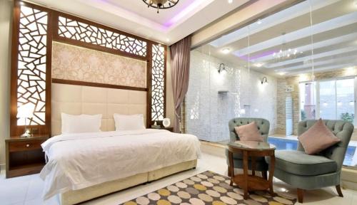 sypialnia z łóżkiem i 2 krzesłami w obiekcie شاليهات لوسيرن (عوائل) w mieście Chamis Muszajt